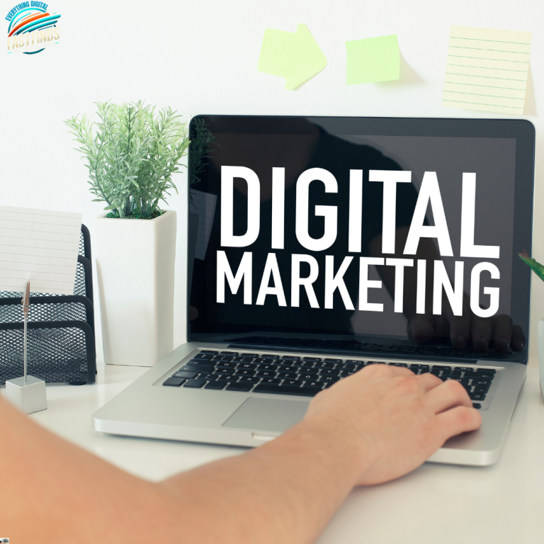 Laptop displaying "DIGITAL MARKETING" with a potted plant and stationery in background.